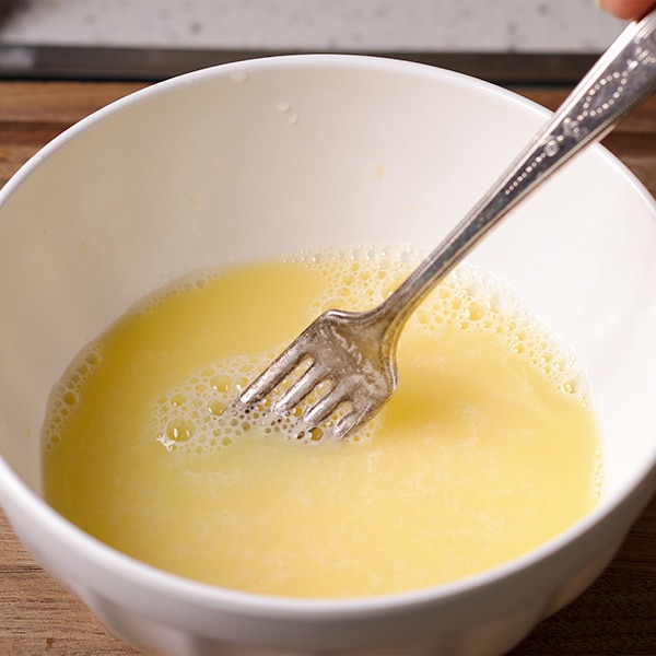 Whisking egg, vinegar, and water in a bowl to make foolproof pie crust.