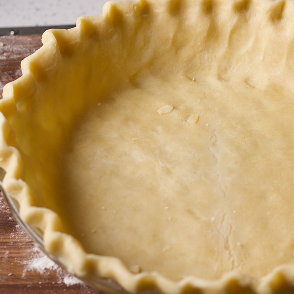 The bottom pie crust, fitted into a pie plate and ready to bake.