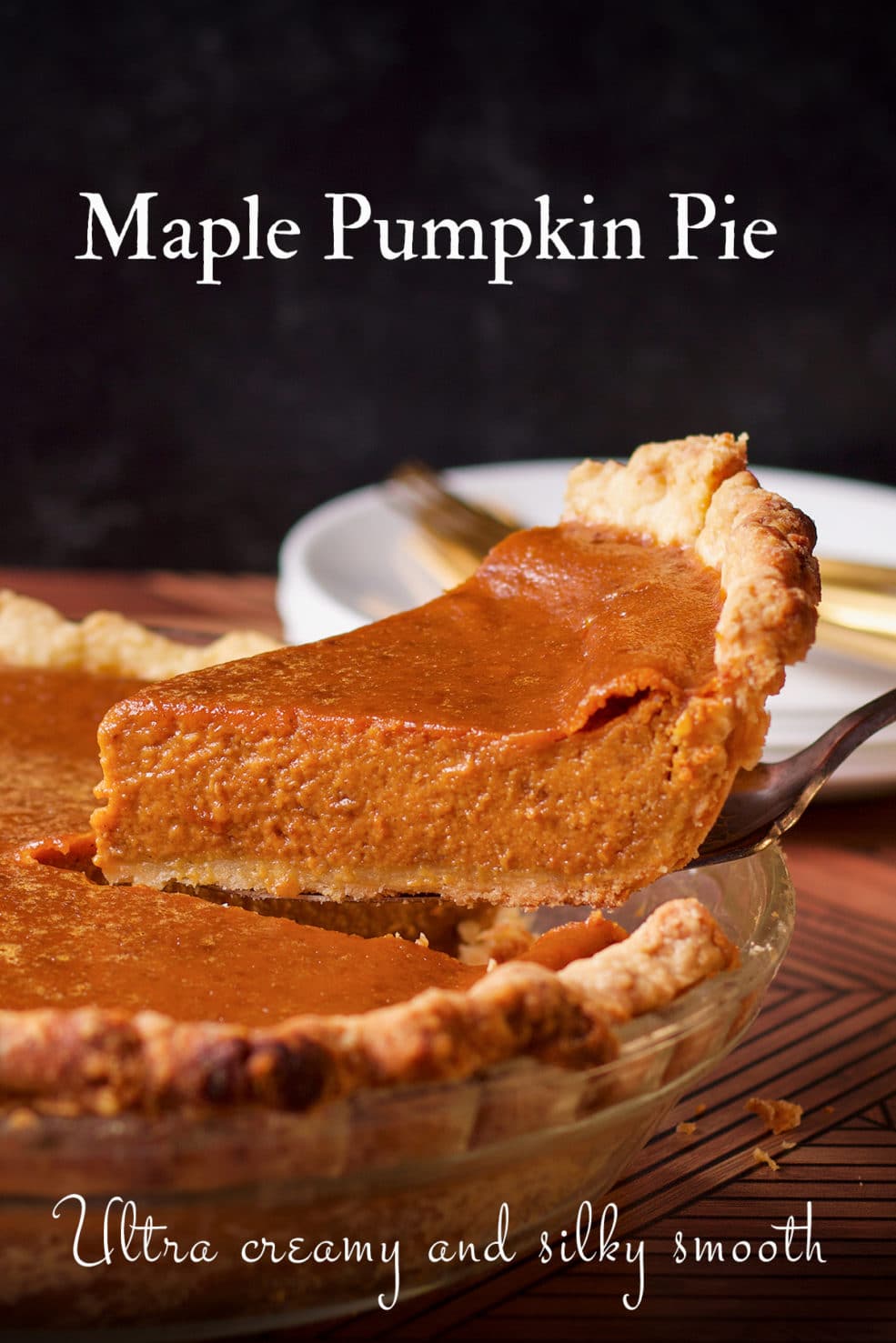 Someone using a pie server to lift a slice of Maple Pumpkin Pie from a pie plate.