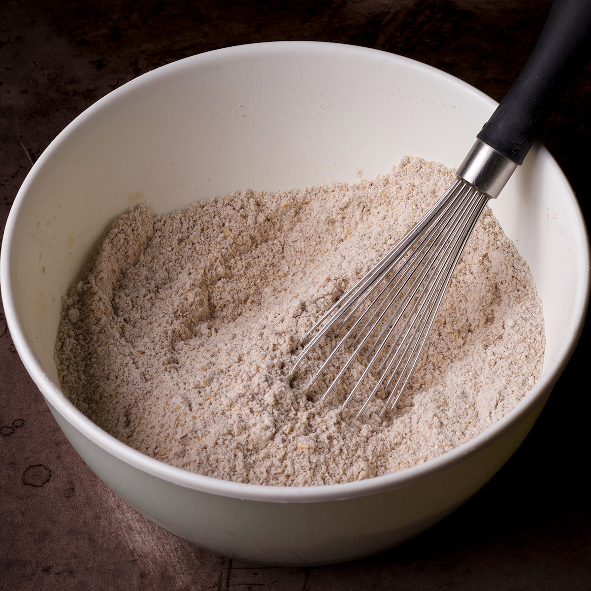 Stirring dry ingredients with a wire whisk.