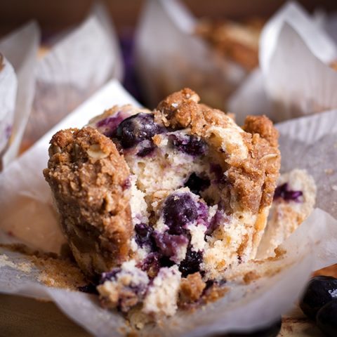A blueberry muffin with streusel broken apart so you can see the middle.