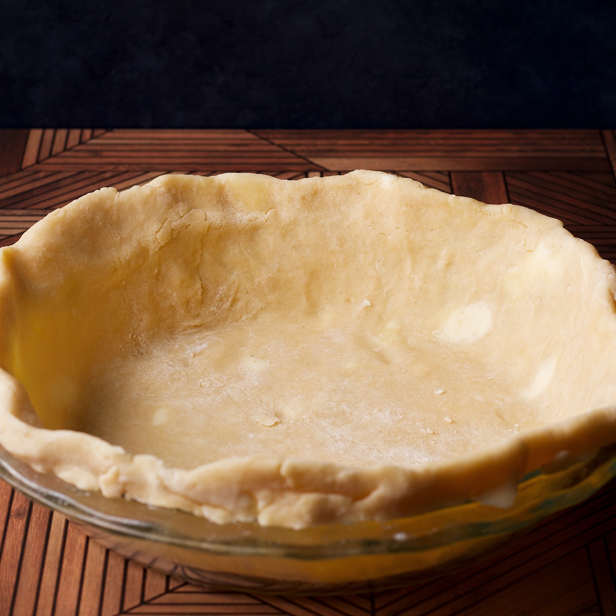 A pie plate lined with raw pie pastry.