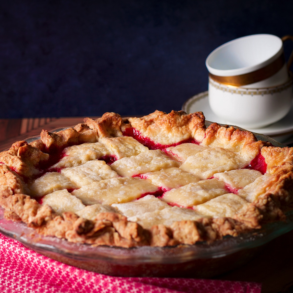 A freshly baked raspberry pie cooling on a table.