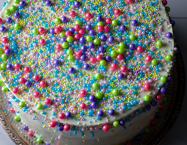 Three-layer vanilla cake frosted with Vanilla Italian Meringue Buttercream and decorated with sprinkles.