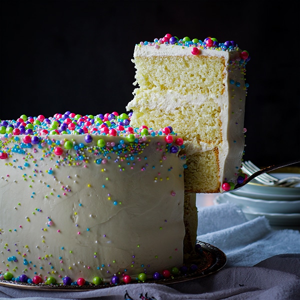 Serving a slice of 3-layer perfect vanilla cake with vanilla Italian Meringue Buttercream