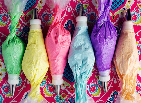 Pastry bags filled with colorful Italian Meringue Buttercream.