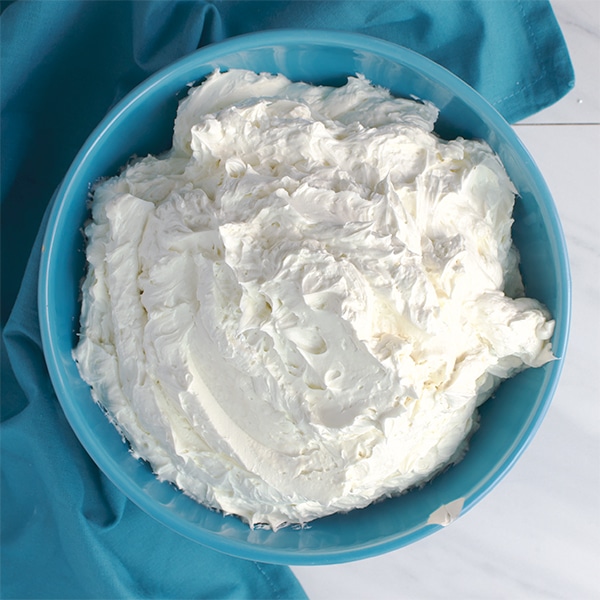 A blue bowl that's filled with Italian Meringue Buttercream.