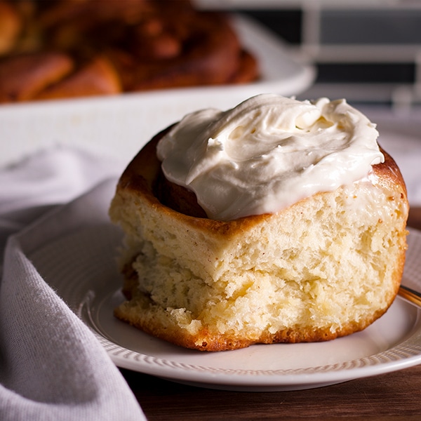 A freshly baked homemade cinnamon roll on a plate, ready to eat.