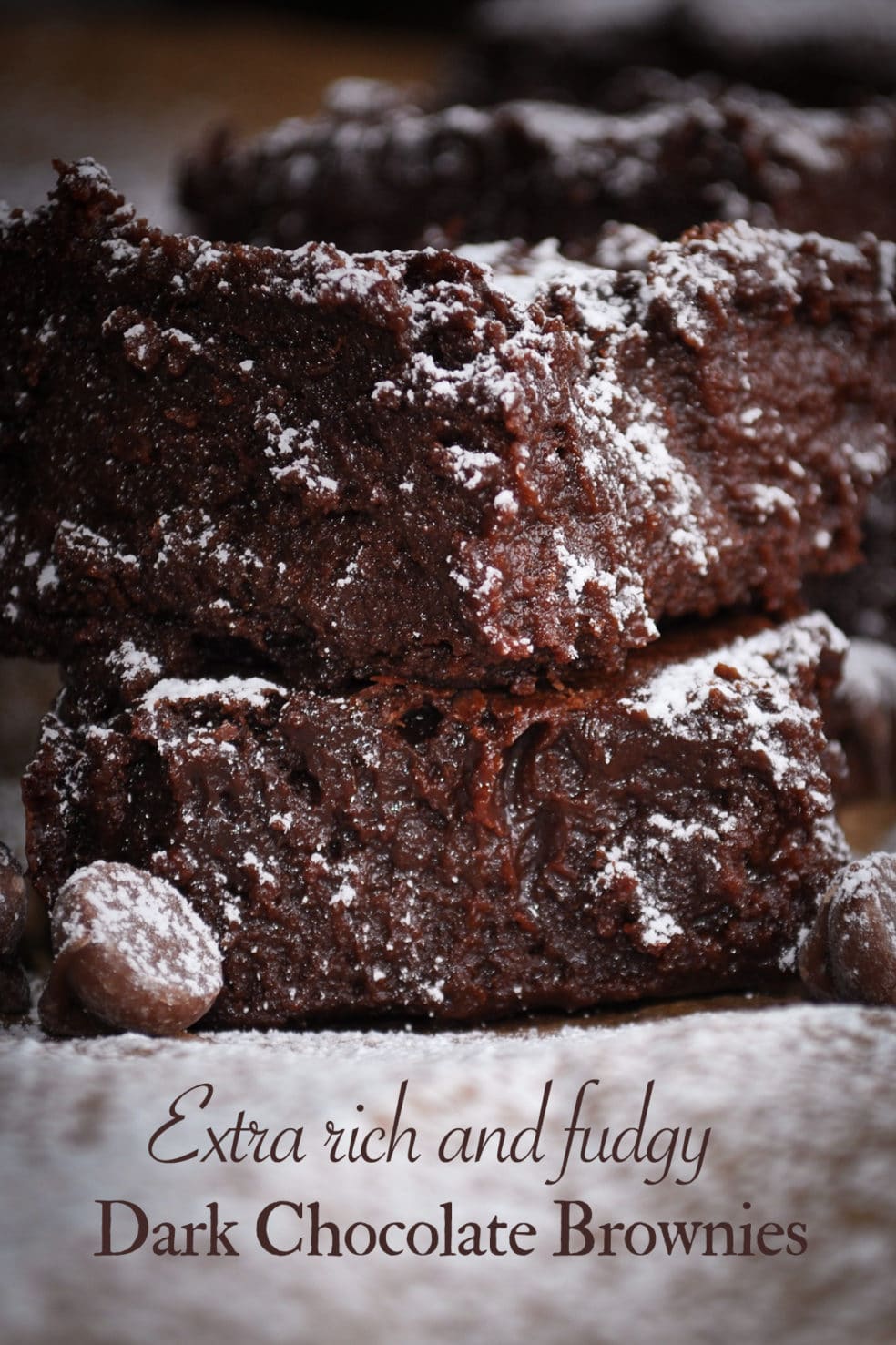 Two dark chocolate fudge brownies stacked on top of each other.