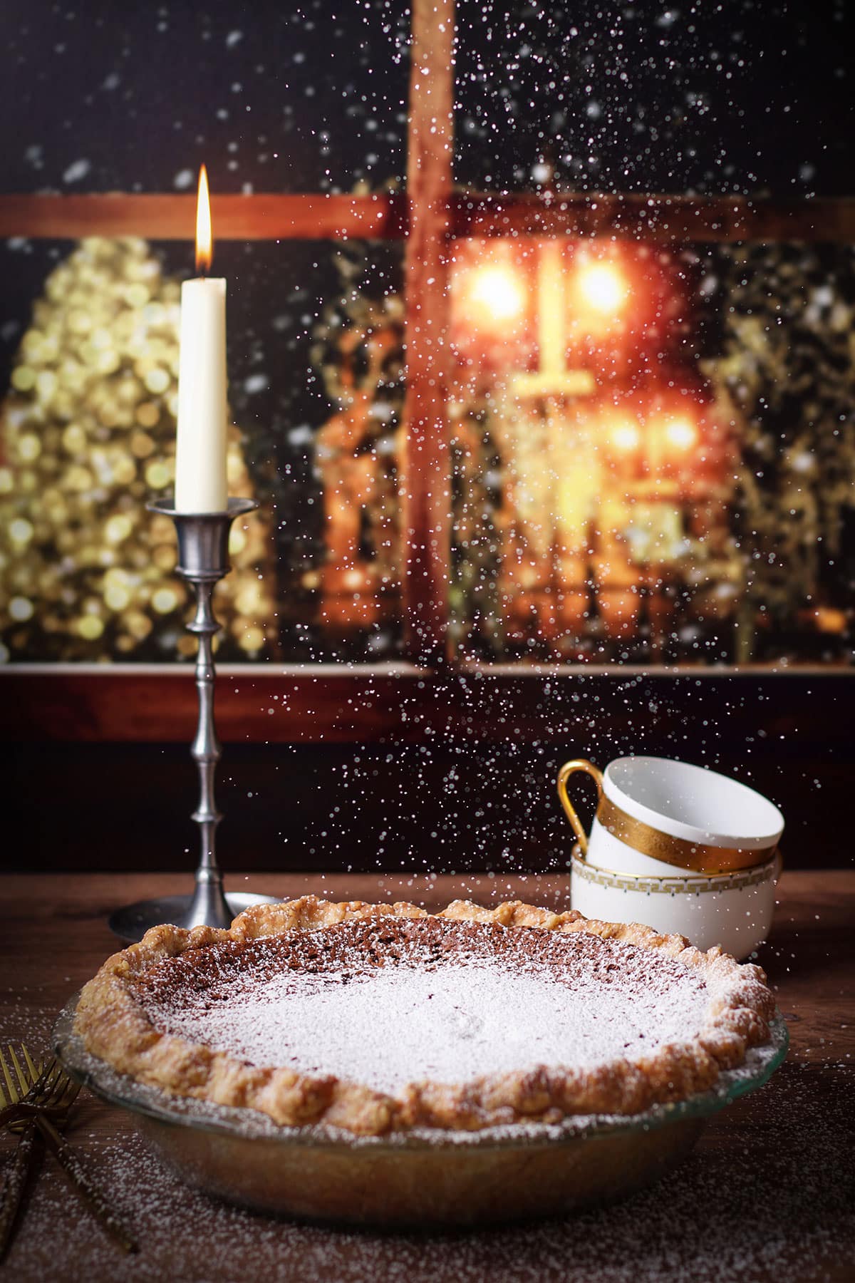 Sprinkling powdered sugar over the top of a chocolate almond pie.