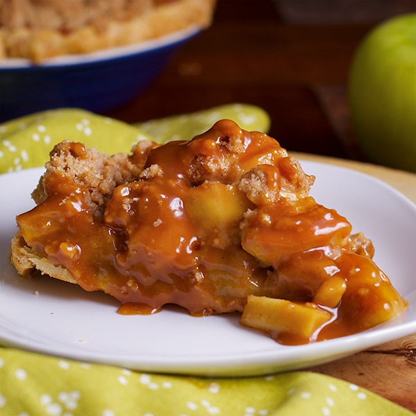 A slice of caramel apple pie on a plate.