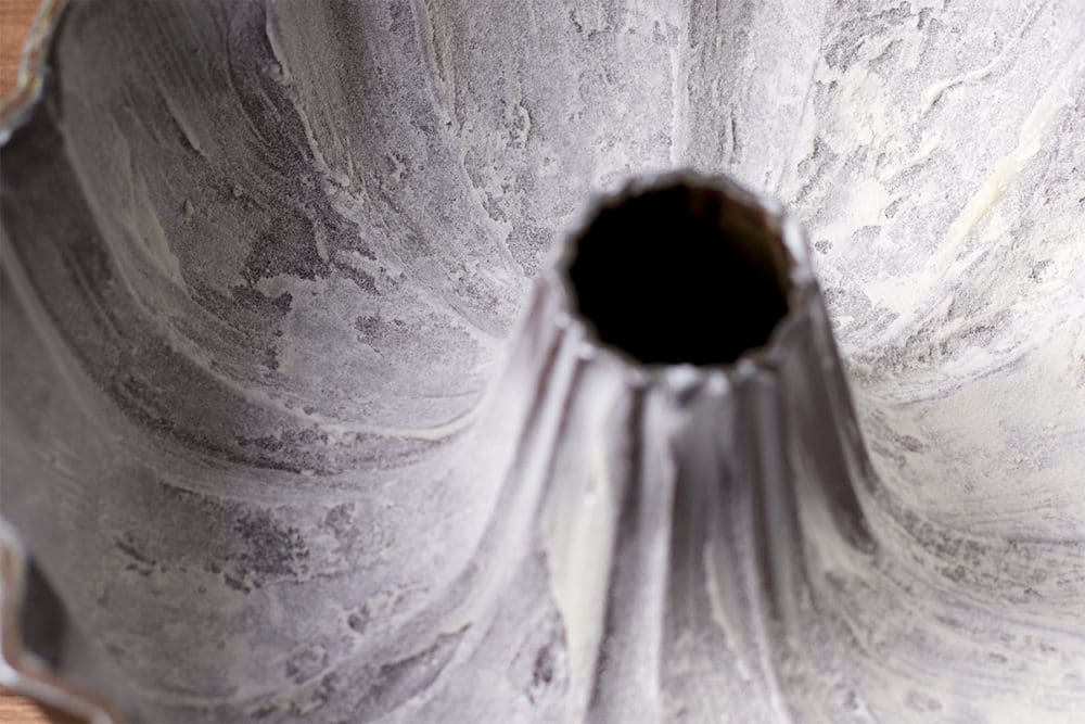 A photo looking down into the inside of a bundt pan to show how it's been coated with vegetable shortening and flour.