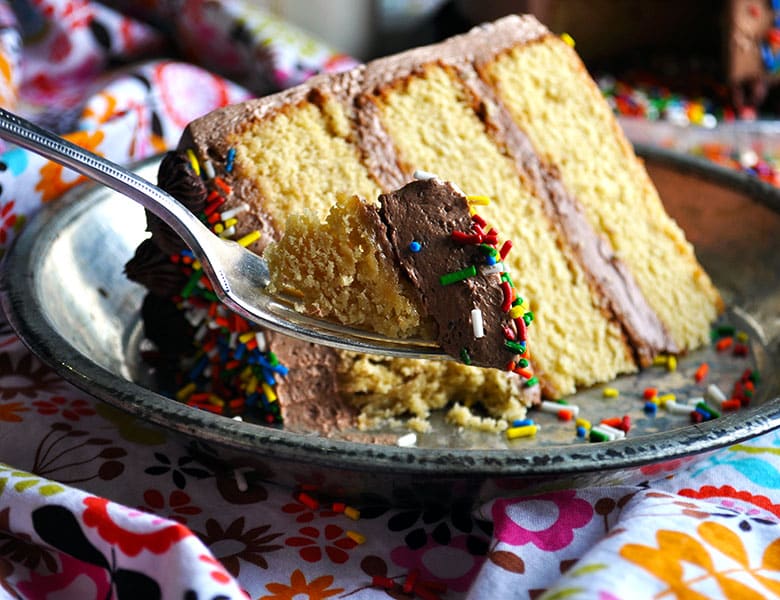 Moist yellow cake recipe with chocolate Italian Meringue buttercream | ofbatteranddough.com