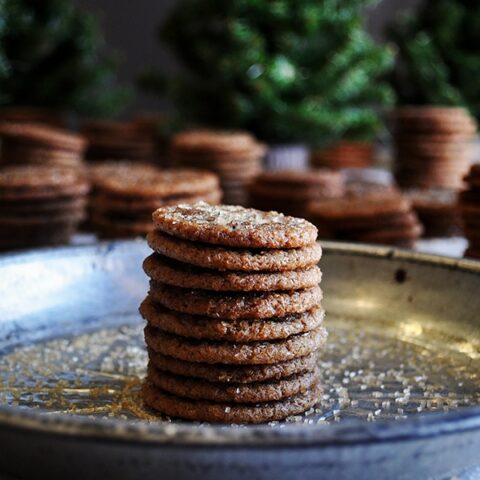 A stack of small chewy ginger snap cookies on a plate.