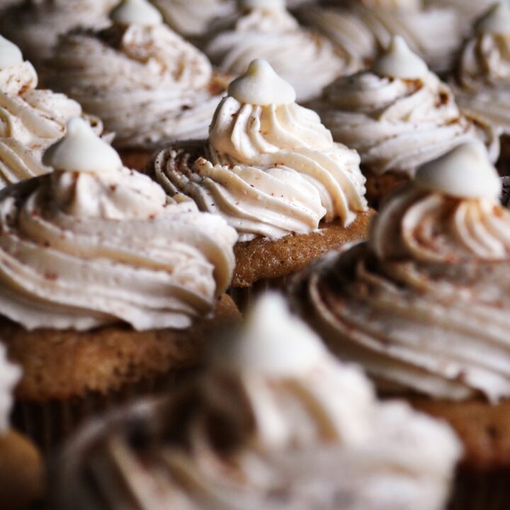 A tray of mini chai latte cupcakes frosted with white chocolate and chai Italian meringue buttercream.