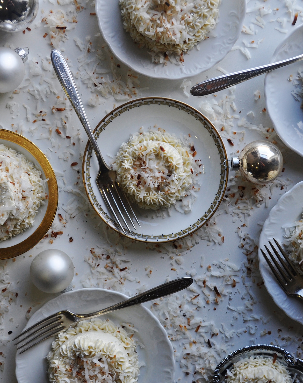 Several plates of mini coconut cakes with maple Italian meringue buttercream.