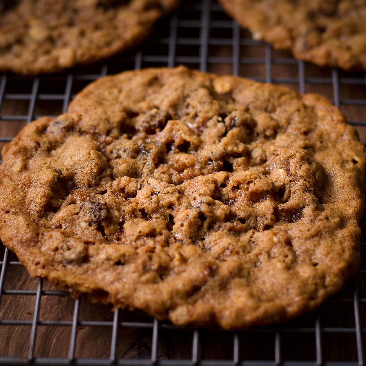 Thin and chewy oatmeal raisin cookies cooling on a wire rack.