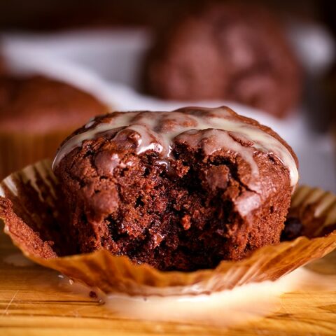 A Chocolate Muffin with a bite taken out of it.