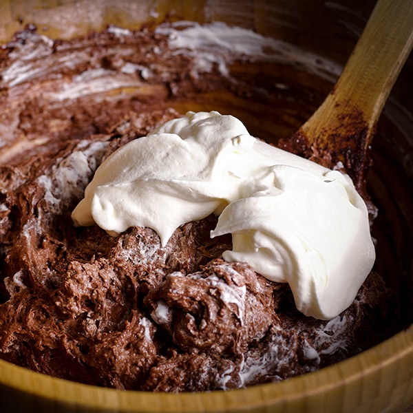 Folding whipped cream into the batter for Double Chocolate Muffins.