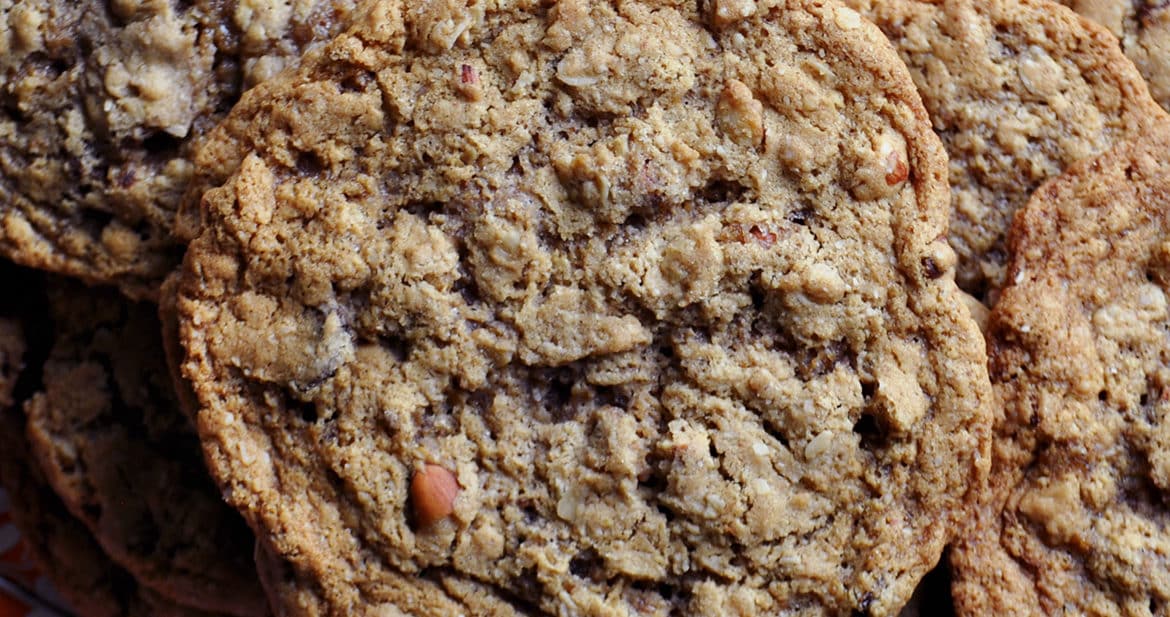 A pile of giant chewy oatmeal raisin cookies. | ofbatteranddough.com