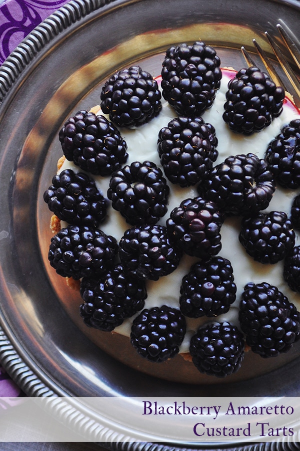 A close-up picture of a blackberry custard fruit tart with amaretto.