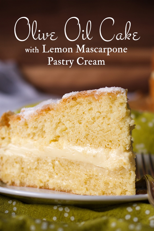 A slice of Olive Oil Cake filled with Lemon Mascarpone Pastry Cream on a plate with a fork.