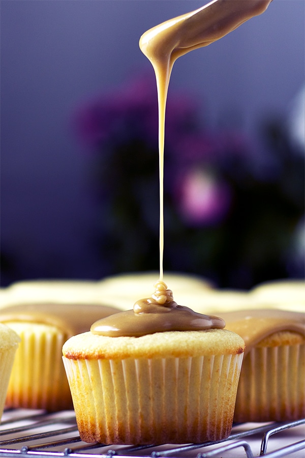 Drizzling caramel frosting over perfect buttermilk caramel cupcakes.
