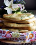A stack of homemade garlic naan breads.