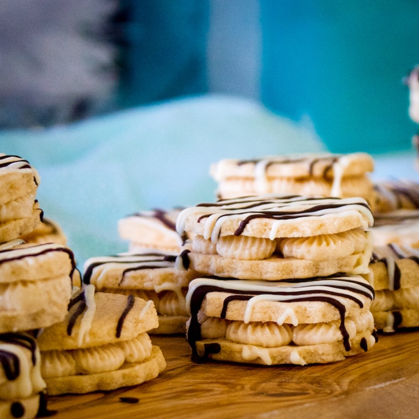 A tray of white chocolate malted shortbread sandwich cookies filled with halva buttercream.