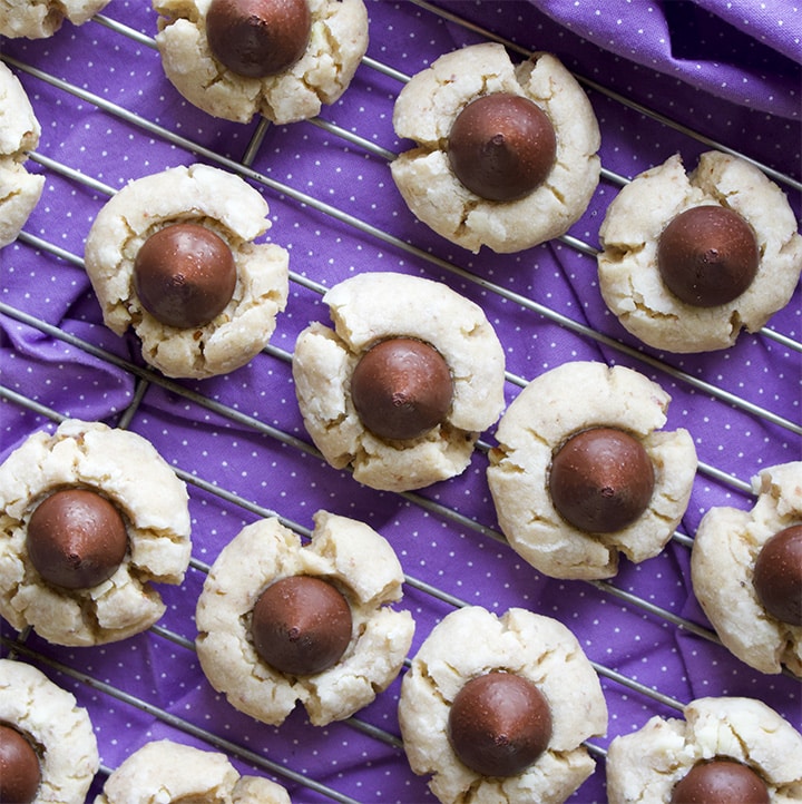 Pecan Sand Tart cookies with chocolate kisses cooling on a baking rack.