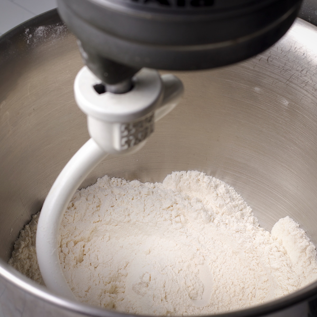 Using a stand mixer to blend flour, baking powder, and salt.