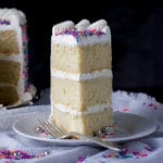 A slice of Gluten Free Vanilla Cake with Italian Meringue Buttercream