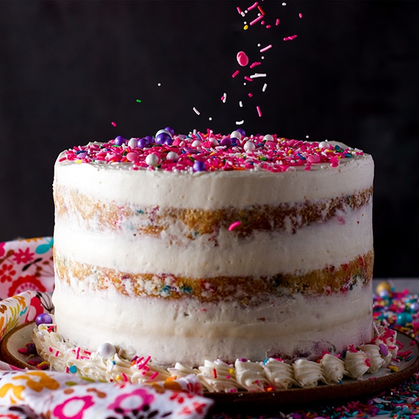Adding sprinkles to the top of a Funfetti Cake with Classic American Buttercream.
