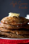 A stack of Apple Cinnamon Pancakes with butter and maple syrup.