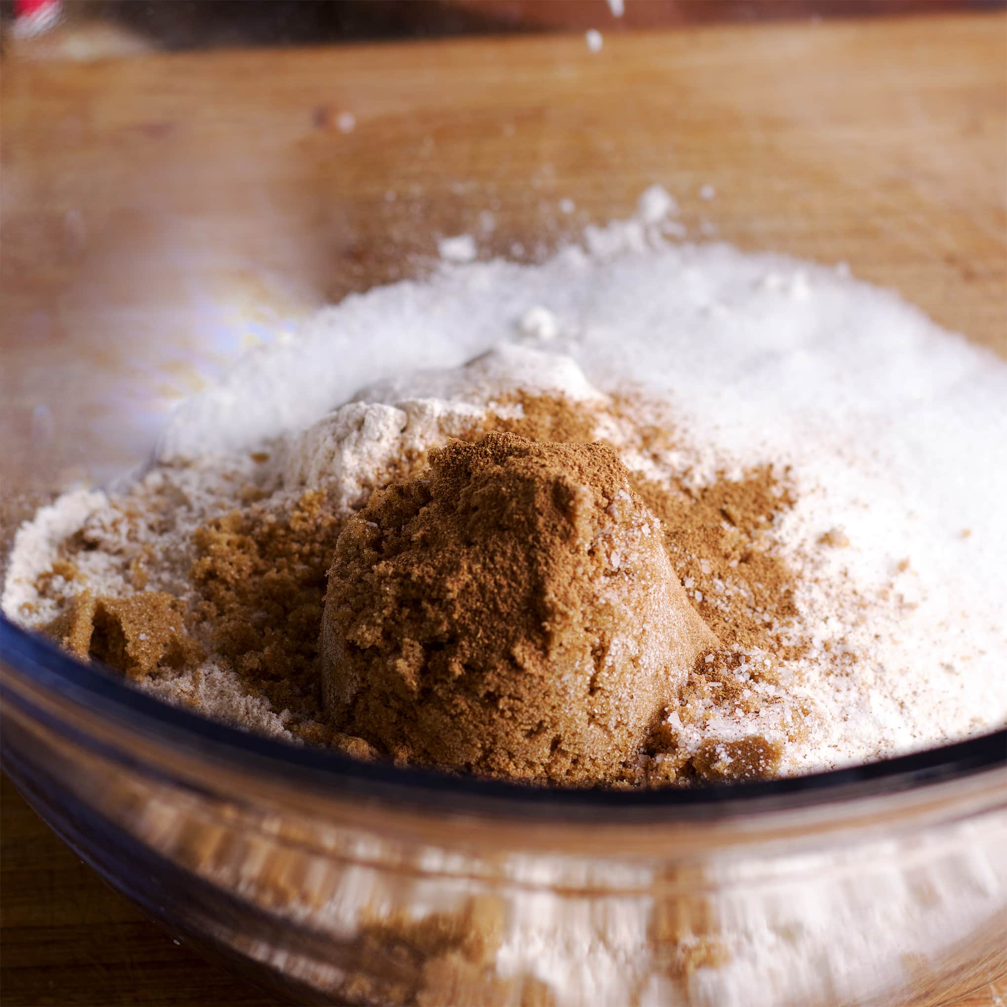 A glass bowl containing the dry ingredients needed to make a crumb topping.