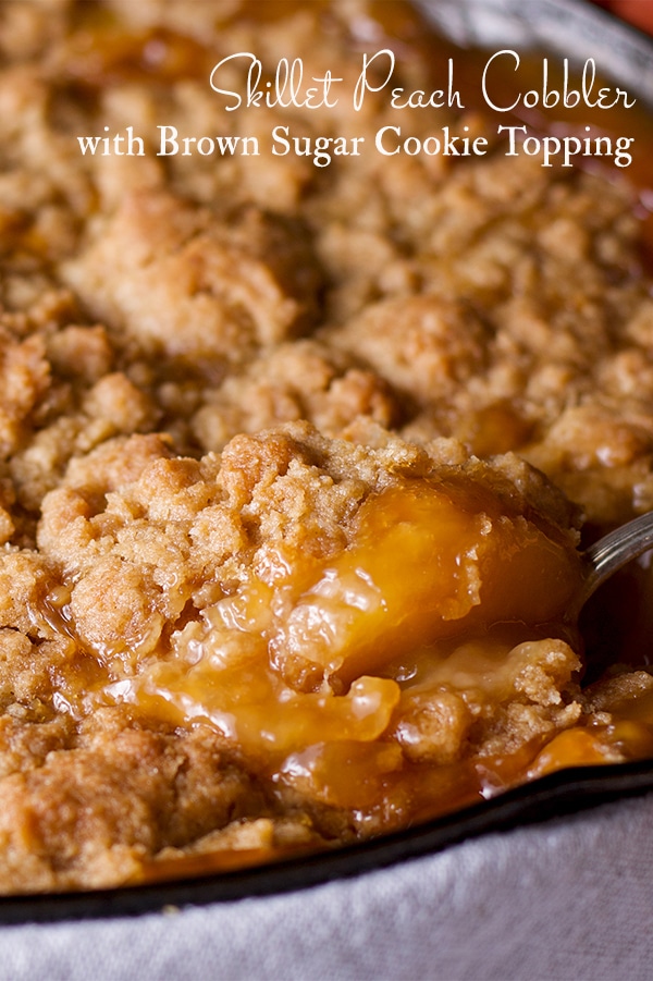 Summer peach cobbler with brown sugar cookie topping, cooked in a cast iron skillet.