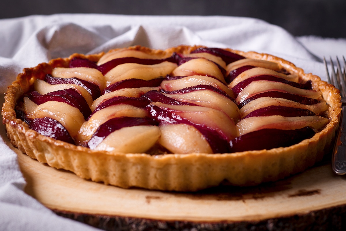 A poached pear and frangipane tart that's just been glazed with a white wine reduction.