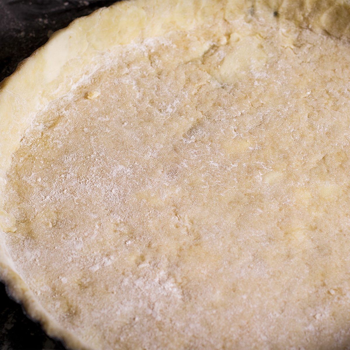 A tart pan that's been fitted with tart pastry dough.