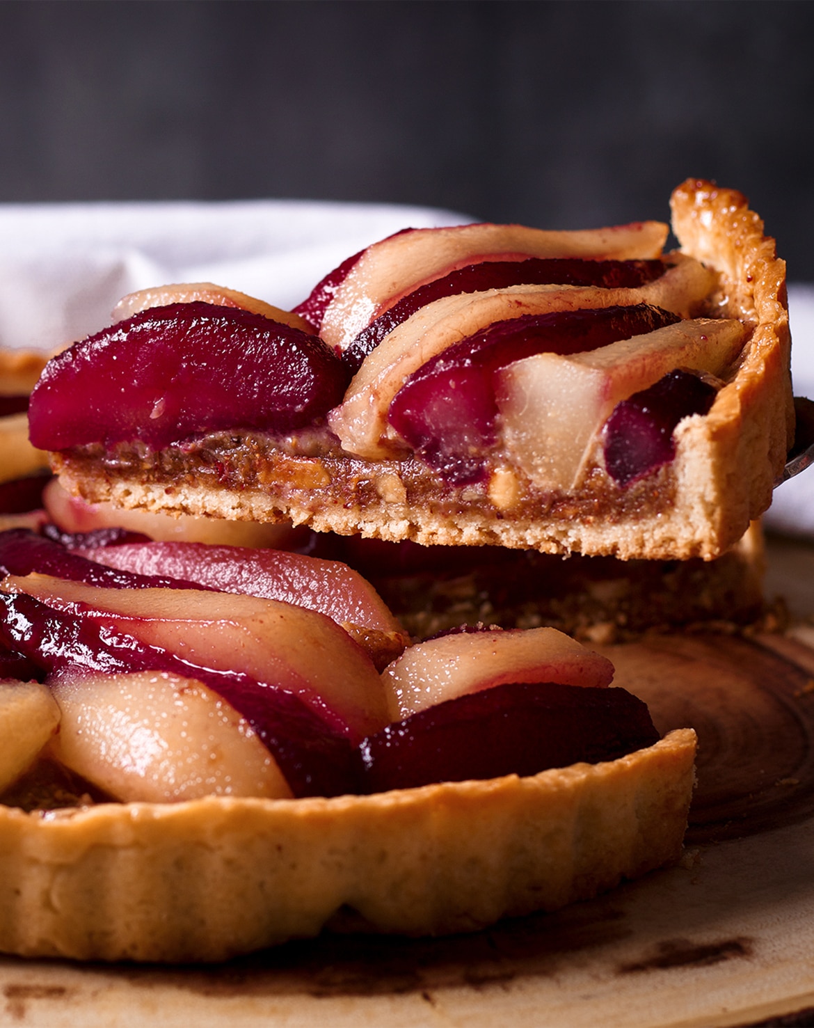 Serving a slice of Pear Tart with Frangipane and Wine Poached Pears