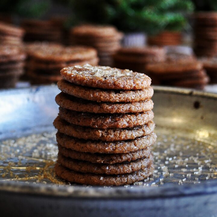 A stack of small chewy ginger snap cookies on a plate.