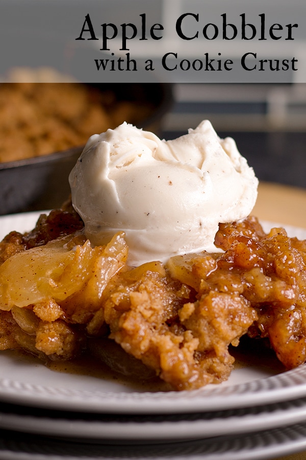 A serving of Apple Cobbler topped with a scoop of vanilla ice cream.