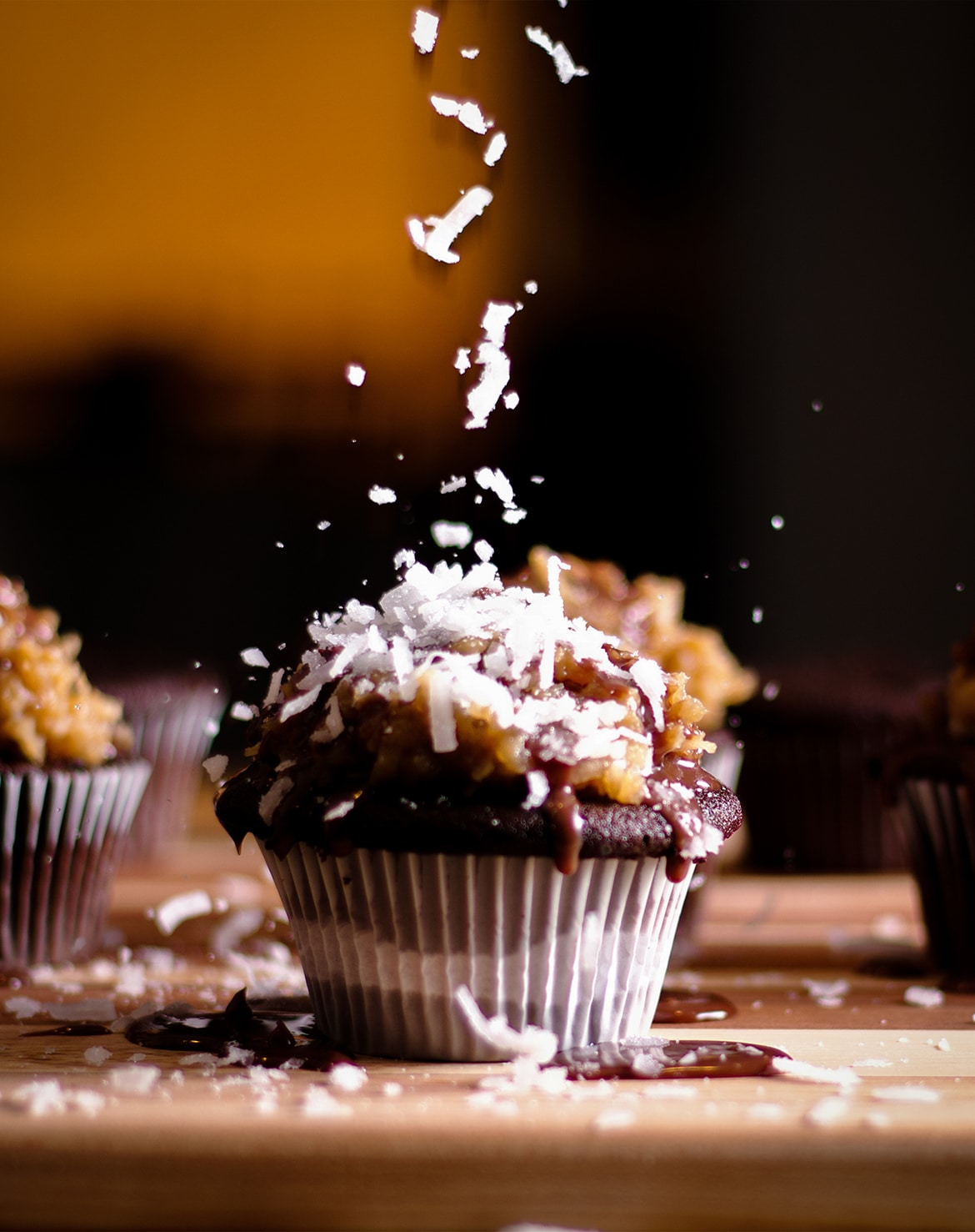 Sprinkling coconut over the top of a German Chocolate Cupcake.