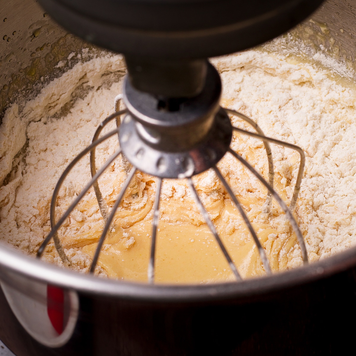 Mixing flour into olive oil cake batter.