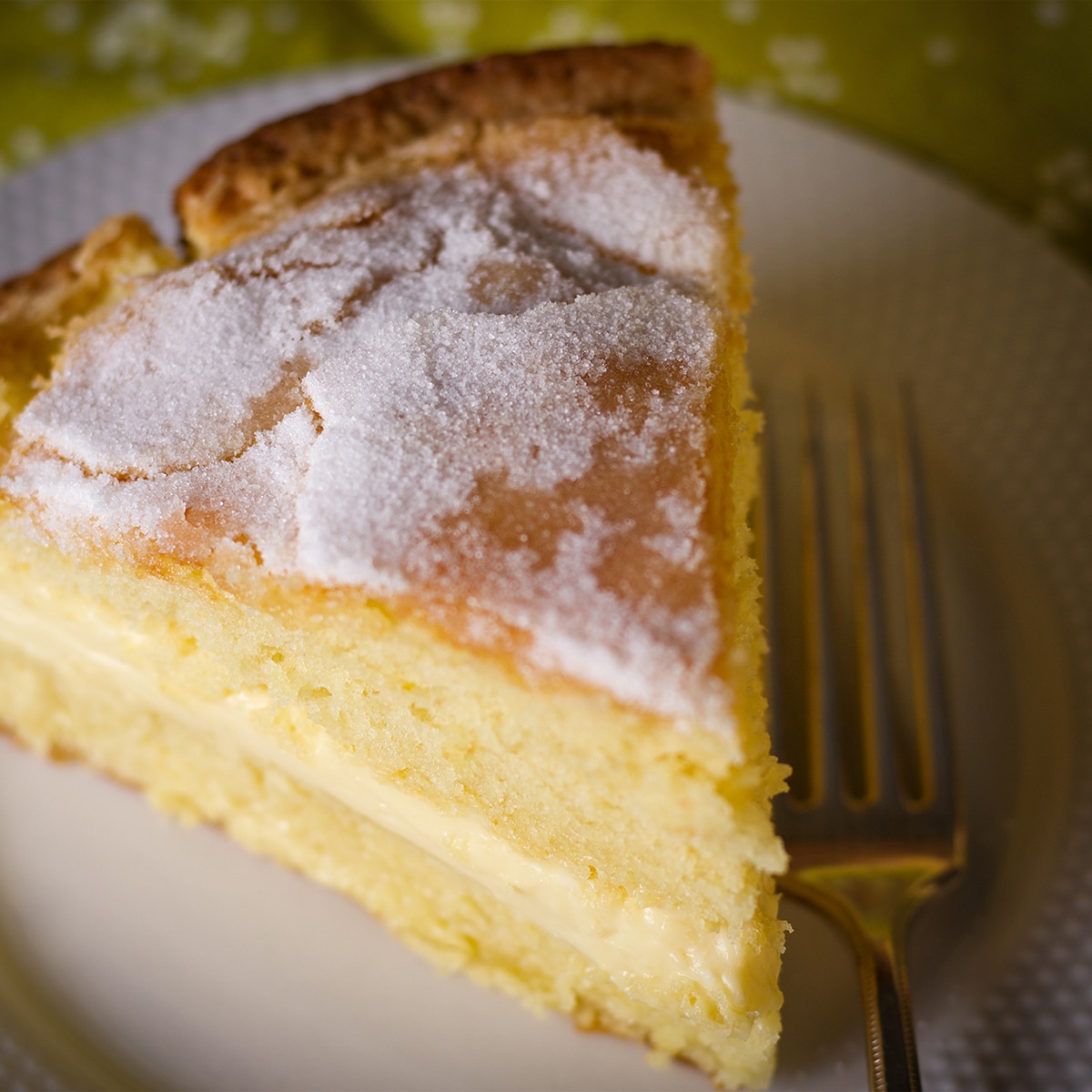 A slice of olive oil cake with a sugary top that's been filled with mascarpone pastry cream.