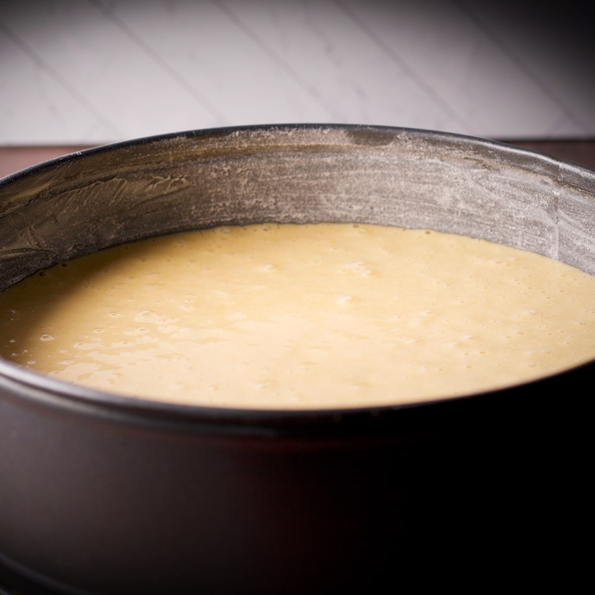 A springform pan filled with olive oil cake batter.