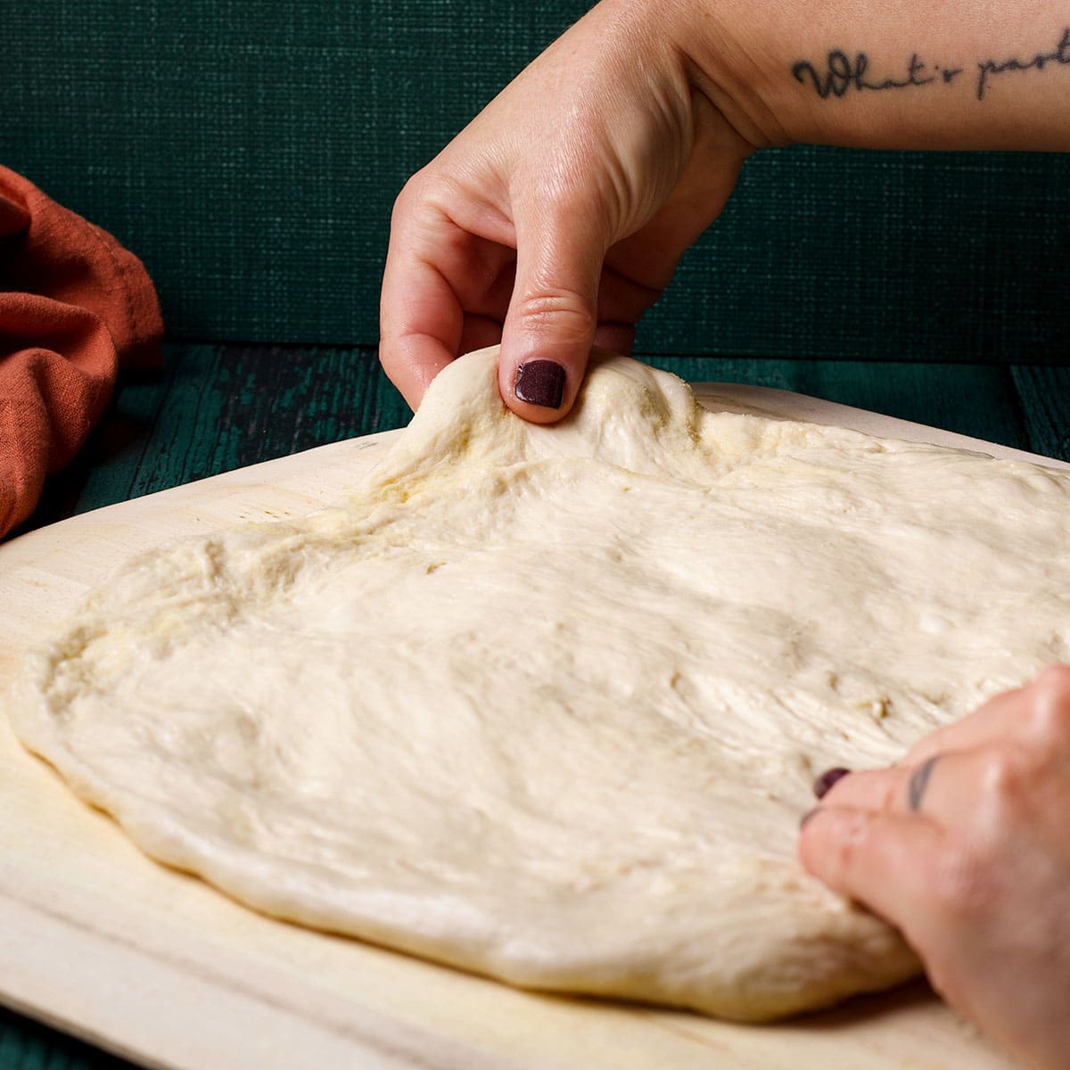 Use your hands to stretch the pizza dough out into a circle.