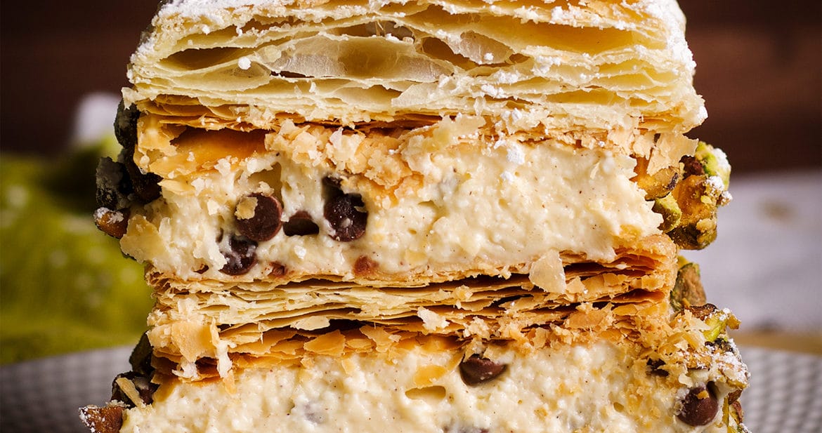 A slice of Cannoli Napoleon on a plate, ready to eat.