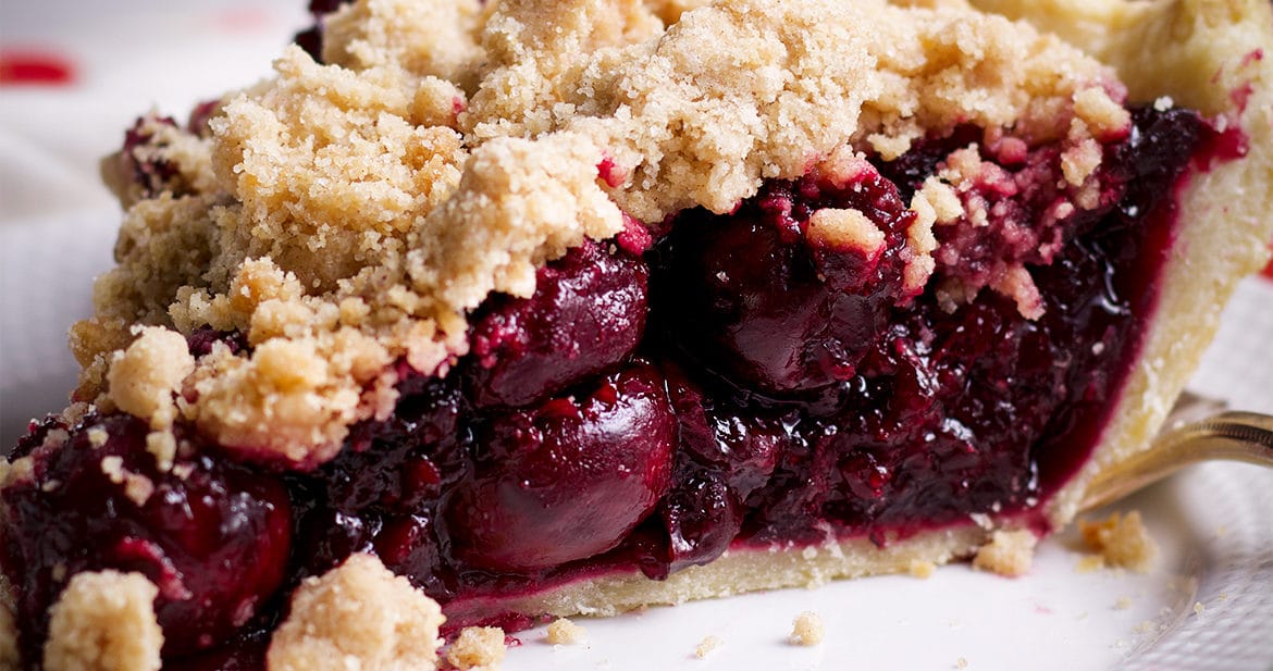 A slice of Cherry Crumb Pie on a plate, ready to eat.