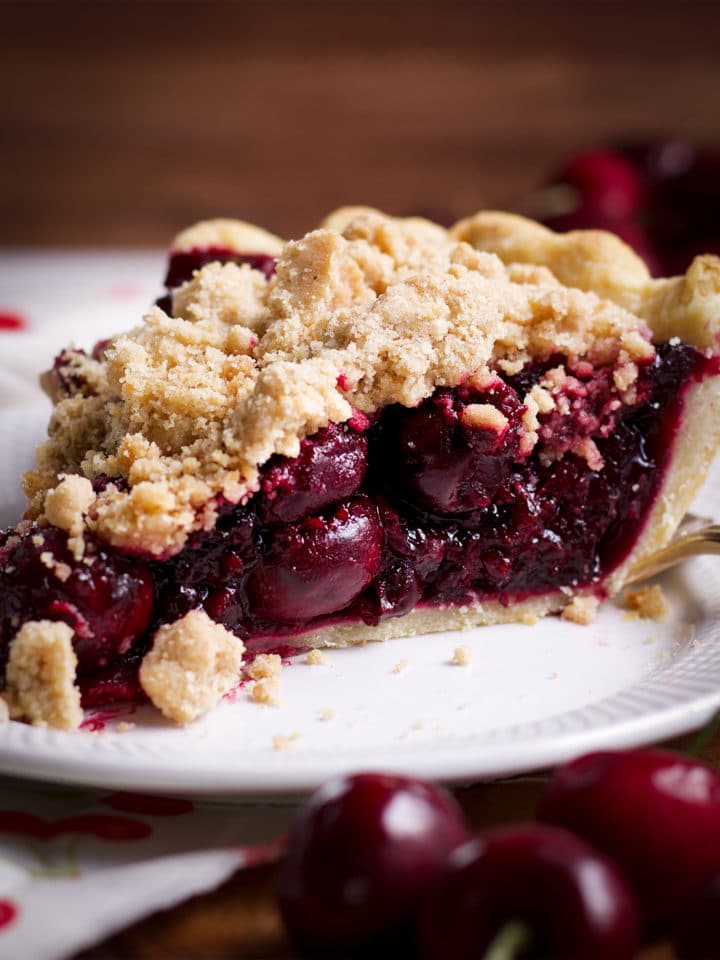 A slice of Cherry Crumb Pie on a plate, ready to eat.