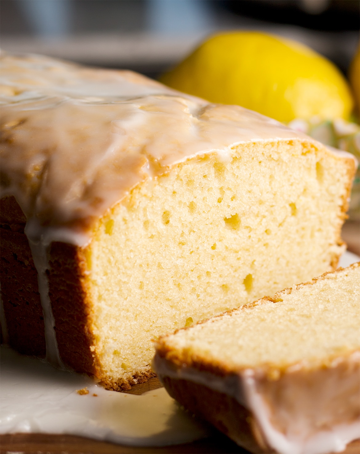 A sliced lemon loaf cake with tart lemon glaze.